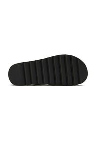 Black rubber shoe sole with horizontal ridges, a rounded toe, and a flat base for improved grip and stability.