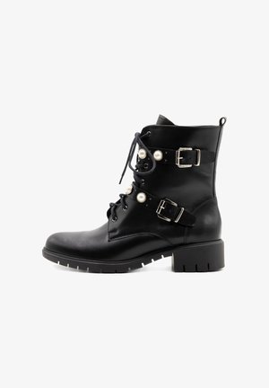 Melnas ādas potīšu zābaki ar masīvu papēdi, auklām priekšā, divām jostu siksnām un siksnām ar pērlēm līdzīgu rotājumu.