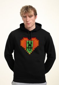 Felpa con cappuccio nera con una grande grafica pixelata di una figura verde all'interno di un cuore arancione. Caratterizzata da cappuccio con cordino e texture morbida.