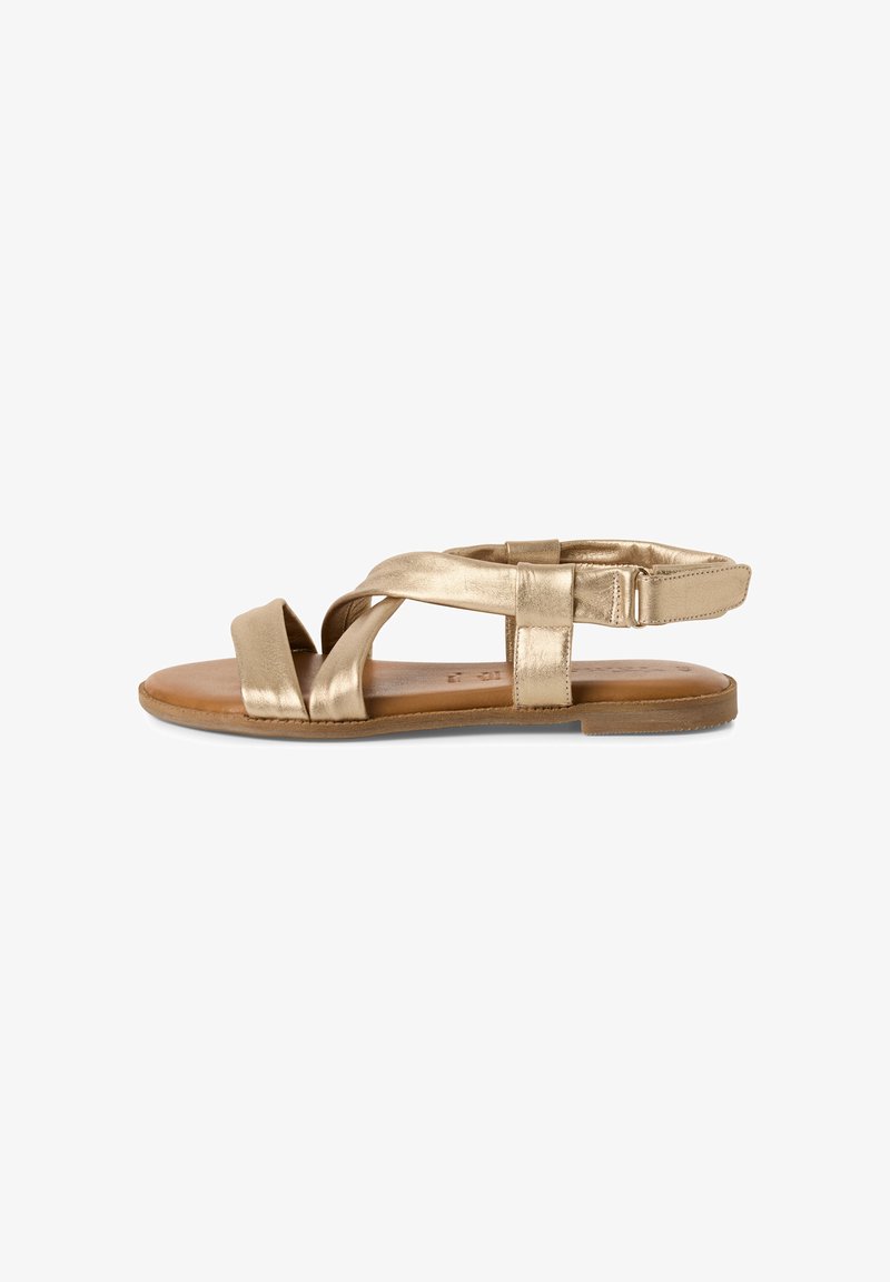 Metallic gold flat sandals with crisscross straps and an adjustable ankle strap. Natural leather footbed and rubber sole.