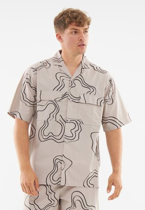 Short-sleeve button-up shirt in light gray fabric featuring black abstract swirl patterns and two front pockets with a relaxed fit.
