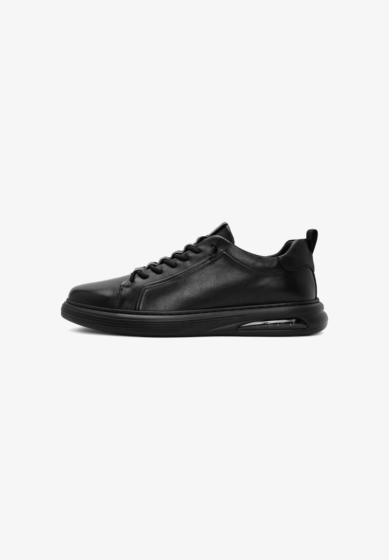 Zwarte sportieve sneakers met een glad leren bovenwerk, vetersluiting, gevoerde kraag, gestructureerde zool en een transparante luchtkussen in de hak.