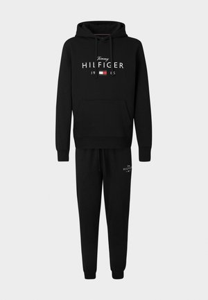 Zwarte hoodie en joggingbroek set met een voorzak, een tailleband met trekkoord, en logotekst in witte en rode accenten. Gemaakt van katoen.