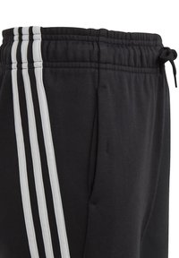 Zwarte trainingsbroek met een trekkoord in de taille, voorzien van drie verticale witte strepen aan de zijkant, zachte stof en zijzakken.