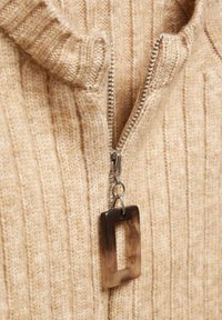 Maglione zip-up beige in maglia con texture a coste. Il cursore della cerniera argentata presenta un accento rettangolare in resina marrone.