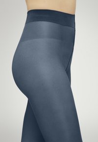Höga midja marinblå leggings tillverkade av ett lent, elastiskt material med en sömlös design och en diskret lyster.