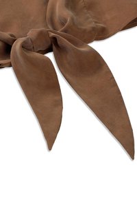 Écharpe en daim marron nouée en un nœud lâche avec deux bouts longs et pointus sur un fond blanc.