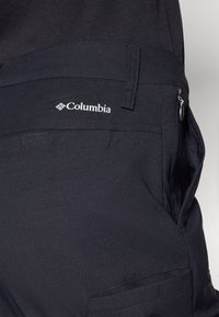 Navy Columbia cargo shorts, valmistettu kestävästä kankaasta, joissa on vetoketjullinen tasku ja erottuvat ommellut yksityiskohdat lisäämään toiminnallisuutta.
