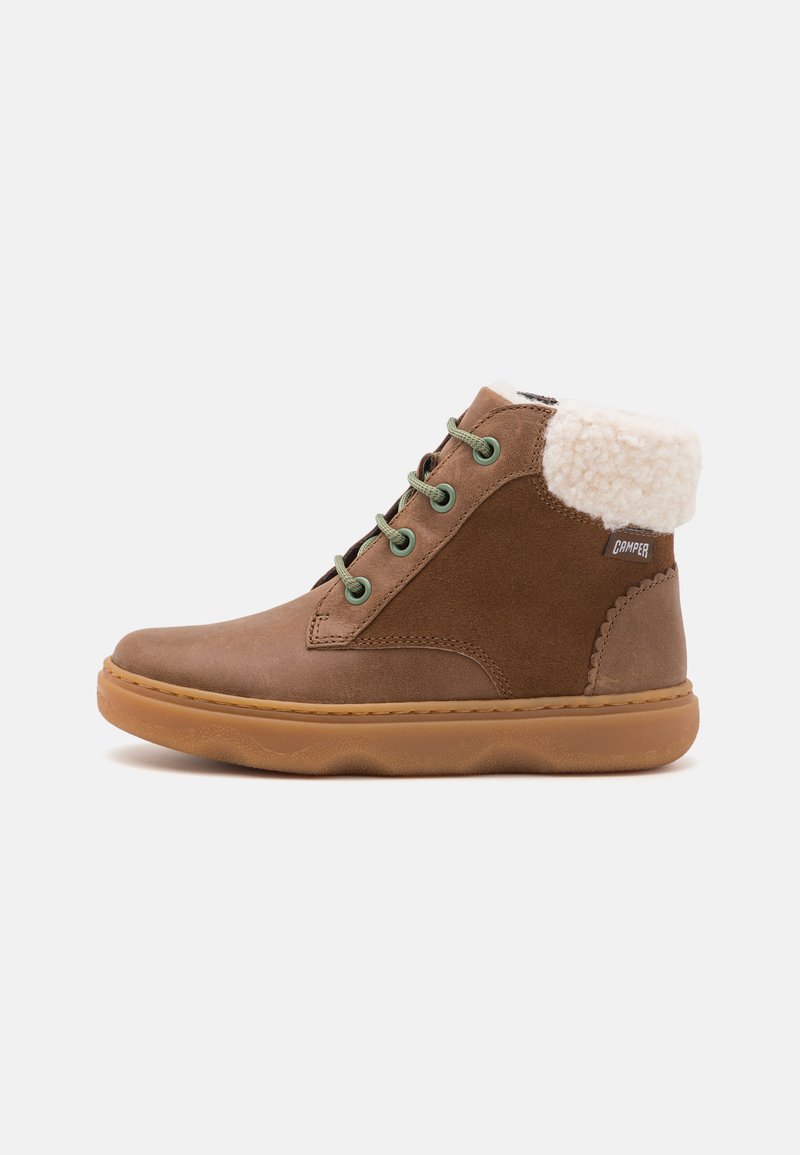 Bota alta marrón hecha de cuero y ante, con un suave cuello color crema, cordones verdes y una suela de goma texturizada.