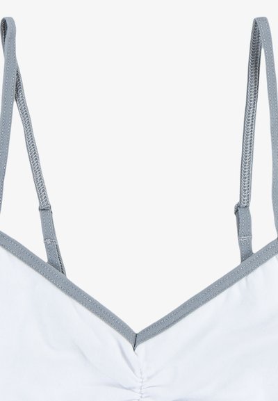 Bela tkanina bralette z V-izrezom, s sivimi poudarki na naramnicah in robovih, ki vključuje zbrano podrobnost na sredini.