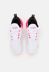 Las zapatillas Nike Air Max 270 cuentan con una parte superior de malla blanca, acentos negros, detalles en rosa y una prominente unidad de amortiguación de aire en la suela.