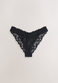 Culotte femme en dentelle noire avec motif floral et bords festonnés, posée à plat sur un fond clair.