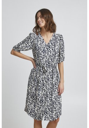 Kleid mit Blumenmuster auf navyfarbenem Hintergrund, kurzen Puffärmeln, V-Ausschnitt, taillierter Taille und lockerem Rock, der oberhalb der Knie fällt.