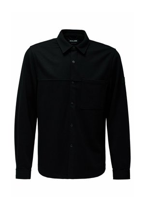 Camisa negra de manga larga hecha de una tela suave, con un frente abotonado, bolsillo en el pecho y cuello estructurado. Presenta un diseño minimalista.
