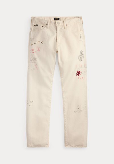 Pantalon beige avec poches avant et passants de ceinture présentant des imprimés graphiques rouges et noirs délavés ainsi que des motifs textuels sur les deux jambes.