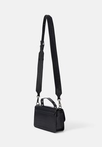 Sac à main en simili cuir noir avec une texture crocodile, doté d'une poignée supérieure, d'une bandoulière réglable et de détails en métal.