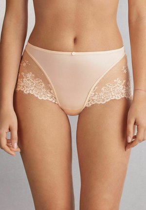 Beige hooggerande onderbroek gemaakt van een glad materiaal, afgewerkt met intriciek kant aan de zijkanten en een kleine decoratieve knop in de taille.