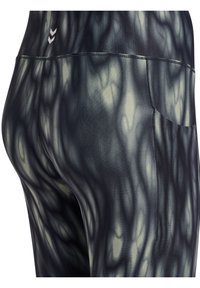 Close-up van zwarte en grijze tie-dye leggings met een achterzak en een klein dubbelpijllogo vlakbij de taille.