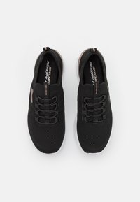 Czarne dzianinowe sneakersy z elastycznymi sznurówkami i teksturowanym wierzchem. Posiadają białą podeszwę oraz subtelne akcenty w kolorze różowego złota na logo.