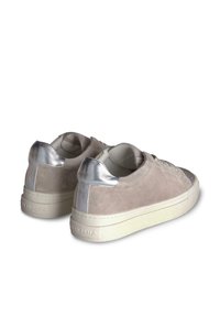 Beżowe zamszowe sneakersy z metalicznymi akcentami, okrągły nosek, teksturowany przód i gruba biała podeszwa. Z tyłu znajduje się metaliczny detal na pięcie.