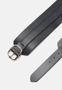 Cintura in pelle nera con una fibbia in metallo dorato. Caratterizzata da una texture liscia, una punta appuntita e fori nazionali per la regolazione della taglia.