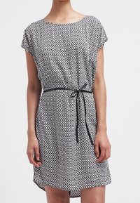 Mönstrad klänning i svart och vitt med en avslappnad passform, korta ärmar och ett svart knytbälte i midjan. Mjuk, lättviken tyg.