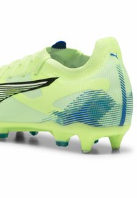 Scarpino da calcio verde lime con tomaia in rete, design con accenti neri e blu, e tacchetti trasparenti. Presenta un colletto imbottito e chiusura con lacci.