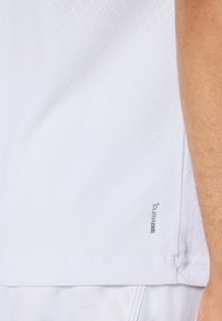 Weißes Sportshirt mit strukturiertem Material, einem ClimaCool-Label am Saum, kurzen Ärmeln und einer lockeren Passform.
