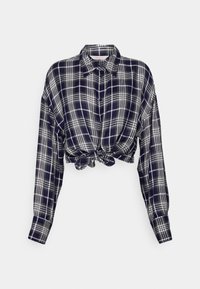 Chemise courte à manches longues avec motif à carreaux bleu marine et blanc, devant boutonné, col et nœud noué à la taille.