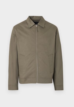 Khaki rohelise lukuga jakk kraega ja kahe esikallutatud taskuga, esitatuna ühevärvilise helehalli tausta ees.