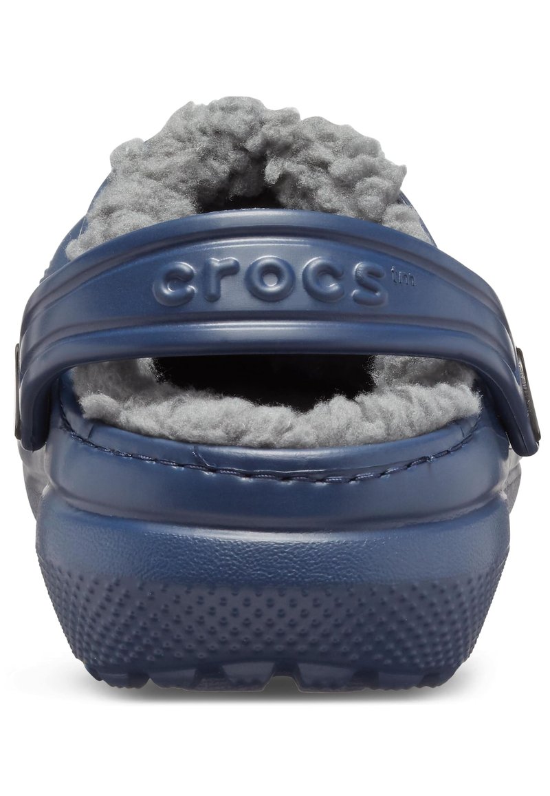 Marineblaue Crocs mit einem kuscheligen grauen Innenfutter, einem stabilen Riemen und einer strukturierten Sohle für Halt und Komfort.
