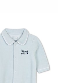 Polo bleu clair à manches courtes avec un col pointu, arborant le texte brodé en marine "Bisous petit" et un symbole de cœur. Texture en coton doux.