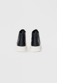 Black high-top sneakers made of smooth leather with a white ribbed sole. Features a rounded toe and minimalistic design.
