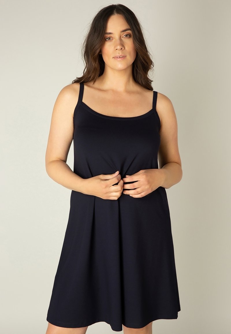 Marineblauwe mouwloze jurk met een ronde hals, flared vorm en zachte stof. Heeft dunne banden en een relaxte pasvorm.