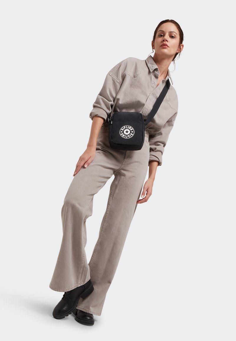 Borsa a tracolla nera in canvas con una grafica circolare, caratterizzata da un design piatto, tracolla regolabile e chiusura a zip.