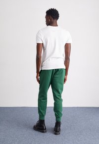 Nike Sportswear CLUB JGGR - Tepláky - fir/white