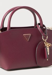 Borsa a tracolla bordeaux con due manici, una borsa rotonda attaccata, hardware dorato e una placca triangolare con il logo Guess.