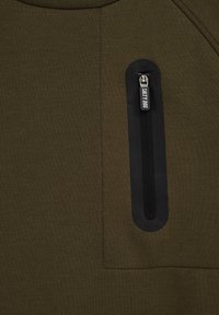 Olíva zöld kapucnis pulóver textúrált anyagból, bal mellen fekete cipzáras zsebbel és varrott részletekkel.