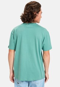 Mint green cotton t-shirt with short sleeves, crew neck, and a relaxed fit. Soft texture and plain design with no visible graphics.