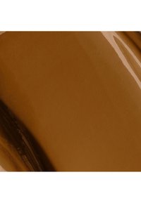 Revêtement liquide brun brillant étalé uniformément sur une surface plane avec des reflets lumineux et des stries brun foncé.
