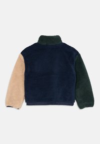 Fleecejakke med høy krage, i fargeblokkdesign med marineblå, grønn og beige. Myk tekstur og avslappet passform.