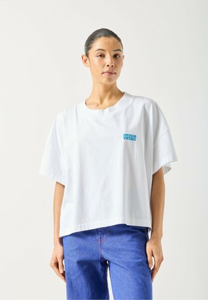 T-shirt bianca oversize in cotone, con scollo rotondo e maniche corte. Logo "AMERICAN VINTAGE" blu sul petto.