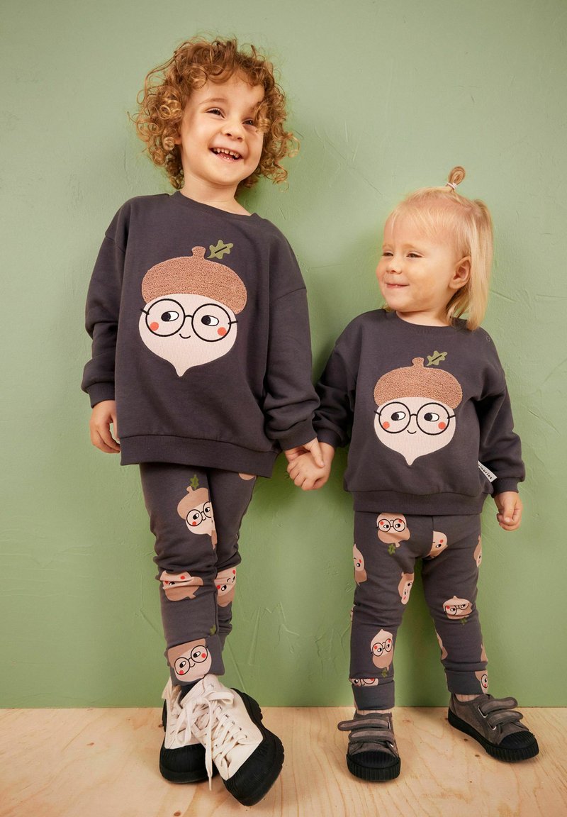 Yhdistelemätön lasten huppari ja leggings-setti tummanharmaana, jossa on leikkisä tammipähkinäkuva, jossa on silmälasit ja lehtikoristeet.