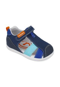 Sandalia de lona azul con una correa de velcro, que cuenta con una suela de goma blanca, un acento naranja y orificios de ventilación.