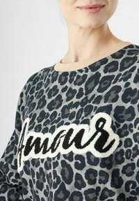 Sweater met luipaardprint in grijs- en zwarttinten, met een getextureerde "Amour" applicatie in zwart en wit, en een beige geribde ronde hals.