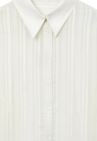 Camicia bianca con bottoni, caratterizzata da sottili righe verticali e colletto a punta, mostrata in primo piano.