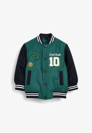 Veste bomber verte et marine avec des manches côtelées à rayures blanches, des boutons et des détails brodés incluant "Cool Dude" et le numéro "10."