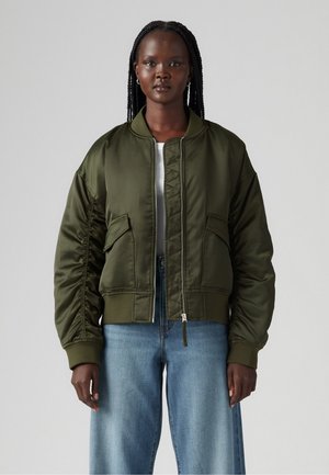 Giacca bomber verde oliva con zip frontale, polsini a costine e due tasche anteriori. Texture satinata liscia con design cropped.