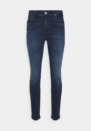 Granatowe jeansy slim fit z pięcioma kieszeniami, zapięciem na guzik i delikatnym przetarciem na przednich udach i kolanach.
