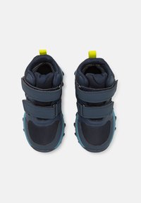 Chaussures pour enfants bleu marine en matériaux en maille et synthétiques, avec deux sangles Velcro et un tirant jaune vif au talon.